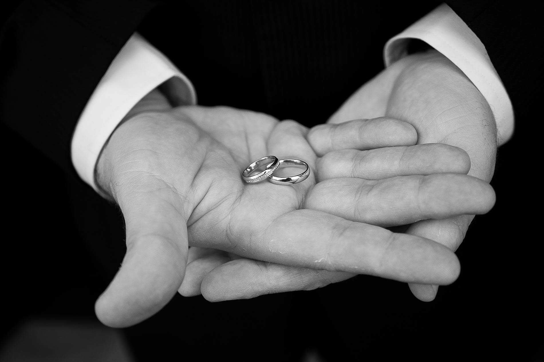best man holding wedding bands