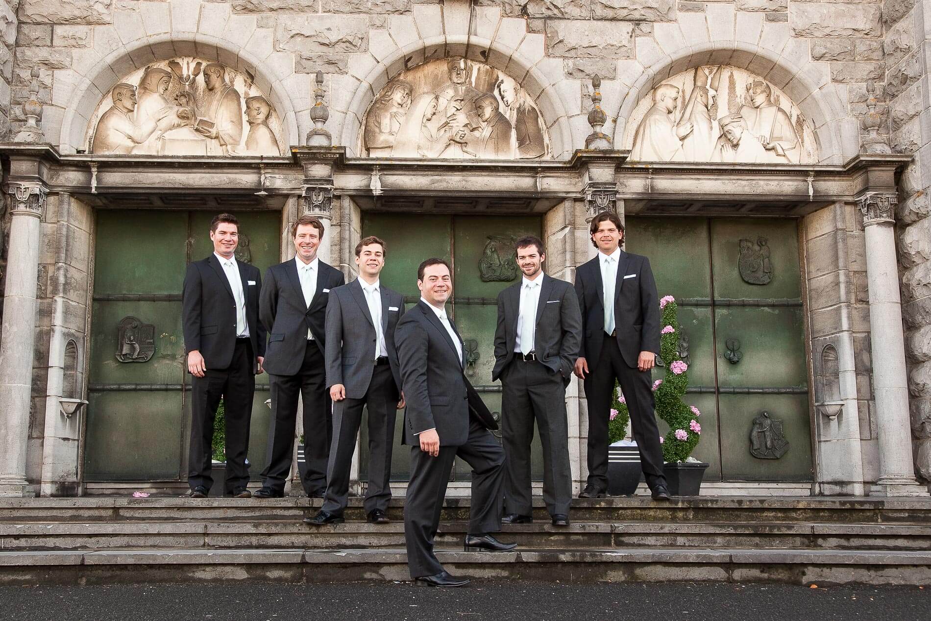 Groomsmen posing in front of cathedral