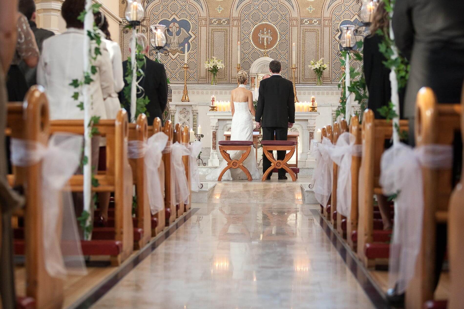 shot of isle in a church looking at bride and groom